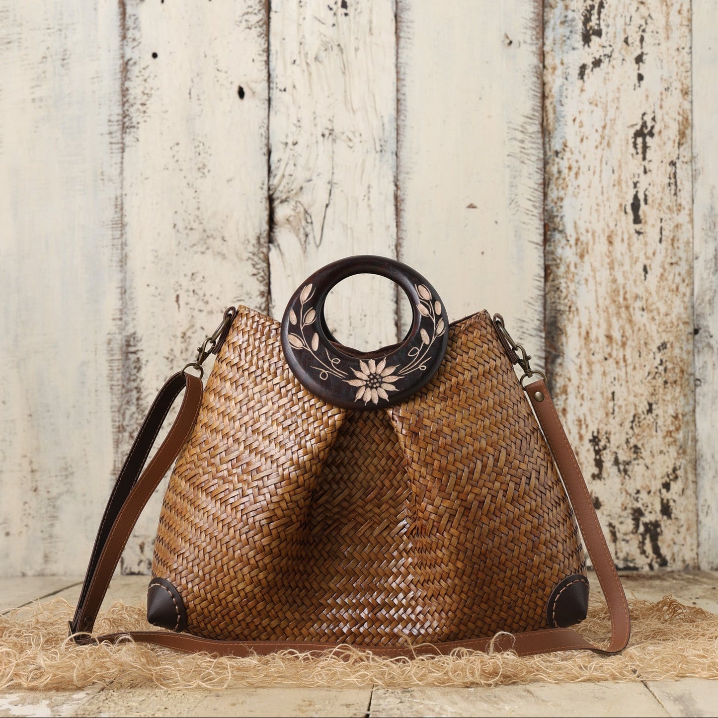 Woven handbag with decorative handle against a wooden background